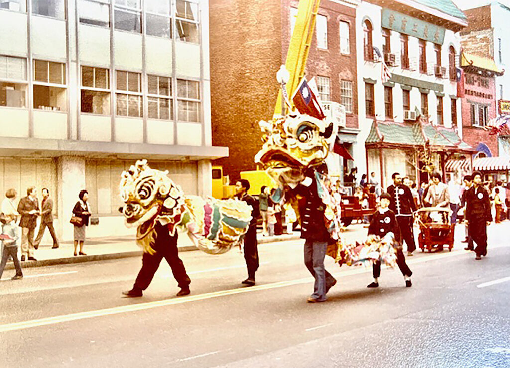 Performers with two Lion Dance costumes and drums parade on the streets of Washington, D.C.'s Chinatown.