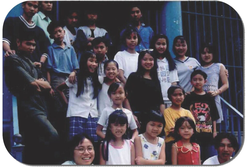 A group of Asian American youth standing on a stairway and posing for a photo.