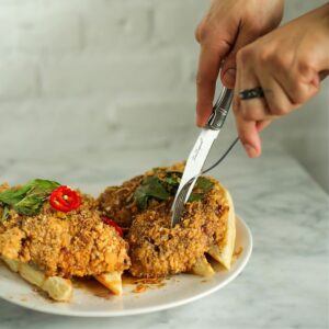 Image of hands cutting Maketto Fried Chicken dish